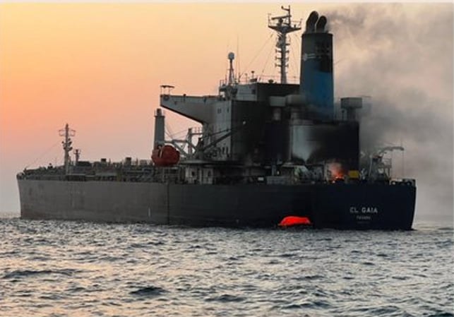 Product-tanker stern, EL GAIA and PANAMA on the house, smoke and flame aft, orange boat in the water.